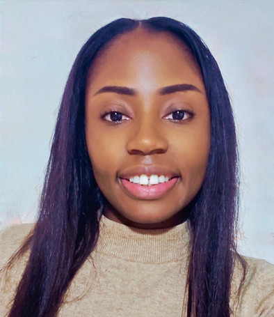 Une femme aux longs cheveux noirs et raides sourit à l'appareil photo. Elle porte un pull à col roulé beige clair et pose devant un fond uni de couleur claire. - Rotary Club Paris Agora