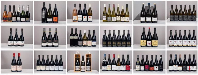 Grille représentant 20 groupes de bouteilles de vin, comme on en trouve dans les ventes de vins. Chaque groupe se compose de trois à cinq bouteilles côte à côte, avec des étiquettes de différents modèles et couleurs sur un fond uni. - Rotary Club Paris Agora